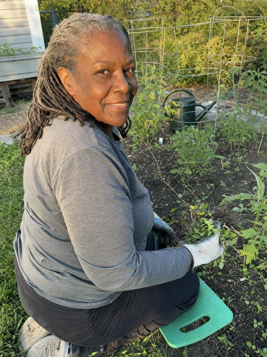 Woman kneeling on a pad in her vegetable garden
