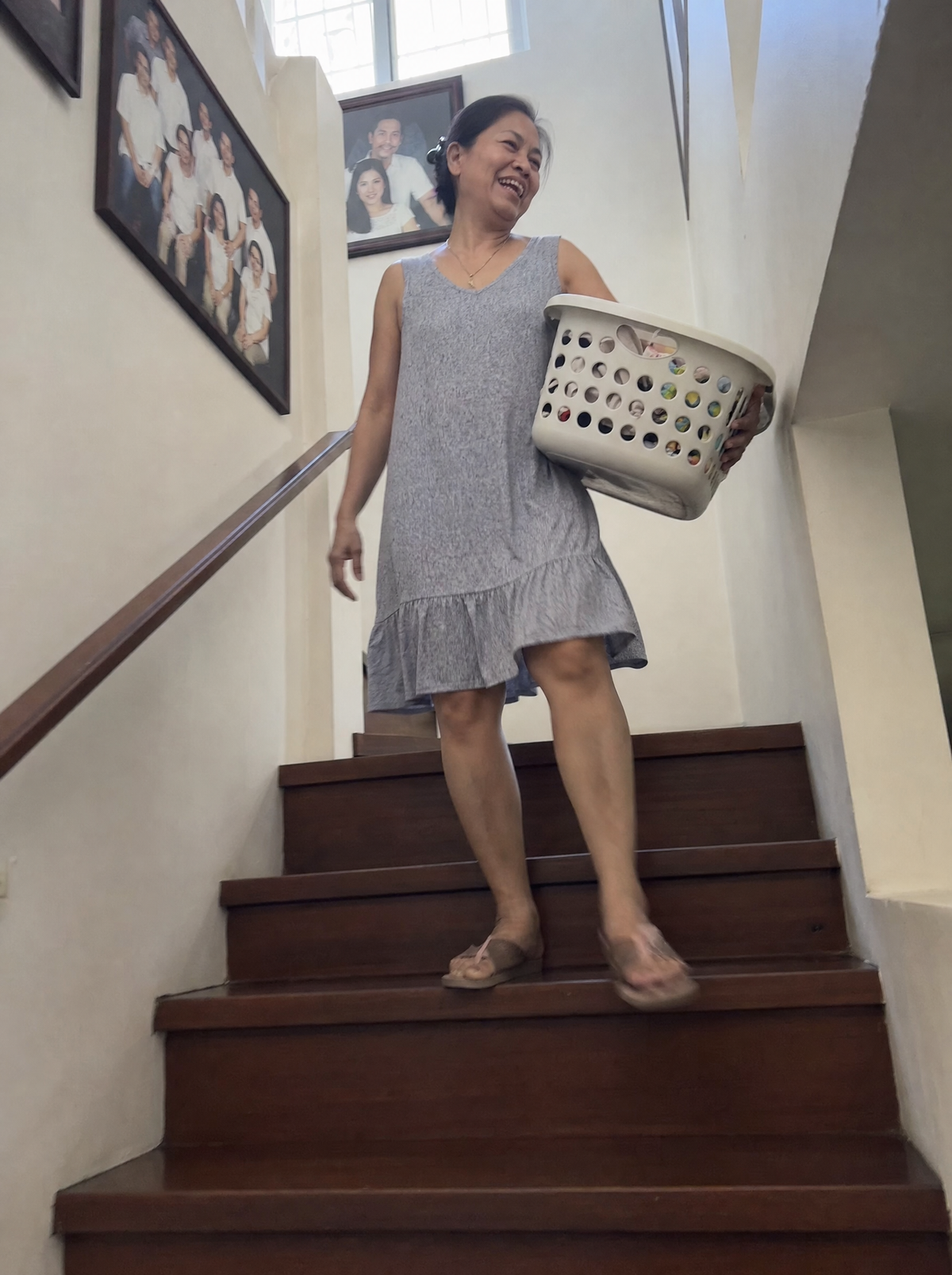 Woman walking down the stairs carrying a laundry basket
